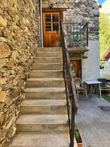 a staircase leading up to a stone building with a wooden door at Au Vialaou - Chez Marcelle in Névache