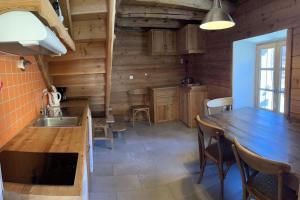 a kitchen with a wooden counter and a table at Au Vialaou - Chez Marcelle in Névache