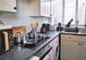 a kitchen with a stove with pots and pans on it at Spacious Apartment -Double and Sofabed -Wonderful Royal Pavilion Views in Brighton & Hove