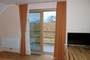 a living room with a large window and a television at Guest House Eco Vila Mila in Rogaška Slatina