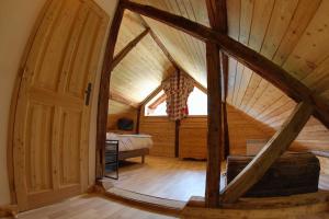 an attic room with a large door and a bedroom at Au Vialaou - Chez Yvonne in Névache
