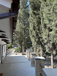 a sidewalk with a row of stone benches next to trees at Monolithos Cottage in Pachna
