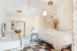 a white bedroom with a bed and a sink at Masseria Ramunno Piccola - Fiora Suite by Rentbeat in Ostuni