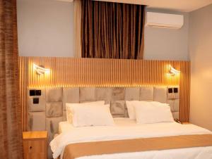 a bedroom with a large bed with white pillows at Edgewoodapartment in Jiru