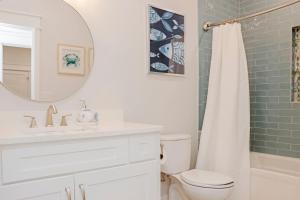 a bathroom with a toilet and a sink and a mirror at Port St Paradise by Pristine Properties Vacation Rentals in Saint Joe Beach +48 photos
