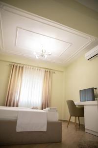 a bedroom with a bed and a desk and a window at Hotel Merkaj in Berat +20 photos