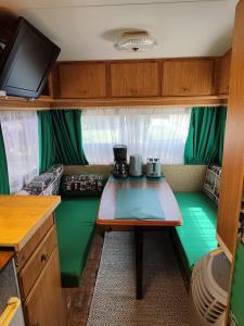 a small kitchen with a table in a caravan at Tiny Anna's Cozy Home near Redbull Ring in Liesingthal