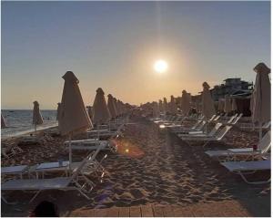a group of lounge chairs and umbrellas on a beach at Francesco's Apartment-Chalkidiki in Flogita