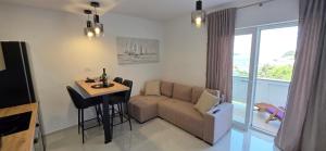 a living room with a couch and a table at Novouređeni apartman Marko, Kampor - Rab in Rab