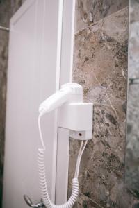 a white phone is hanging on a wall at Hotel Merkaj in Berat