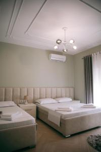 a bedroom with two beds and a ceiling at Hotel Merkaj in Berat