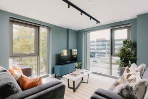 a living room with two couches and a tv at Charles Hope Birmingham Westside in Birmingham