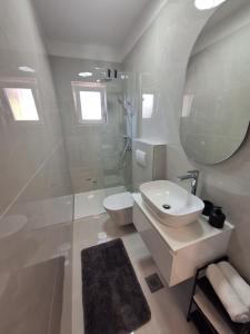 a bathroom with a sink and a toilet and a mirror at Novouređeni apartman Marko, Kampor - Rab in Rab +7 photos