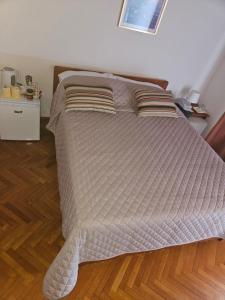 a bed in a bedroom with a wooden floor at " Rooms Bela" balcony in Ičići