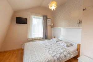 a small bedroom with a bed and a window at Beltes Guest House in Jūrmala +38 photos