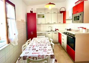 a kitchen with red cabinets and a table with chairs at CasaEolia Golden in Canneto