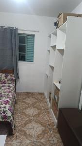 a room with white shelves and a bed and a window at Casa para festival stlg para 2 pessoas in São Thomé das Letras