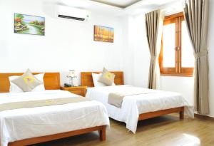 a bedroom with two beds and a window at Khách sạn KIM NGÂN in Quy Nhon +19 photos