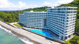 an aerial view of a large building next to the ocean at MaRKoS Sea View Apartment Bamboo Beach in Ts'ikhisdziri