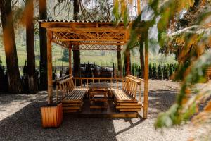 a wooden gazebo with benches in a park at MaRKoS Sea View Apartment Bamboo Beach in Ts'ikhisdziri