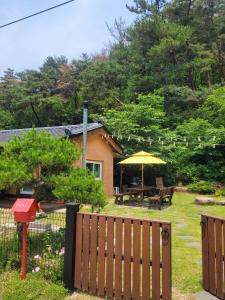 a house with a wooden fence and an umbrella at Gyeongju Moon Rabbit in Gyeongju