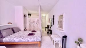 een kleine witte kamer met een bed en een tafel bij Los cristianos Vistas al mar y cerca de la playa in Los Cristianos +21 foto's