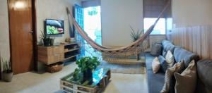 a living room with a couch and a hammock at Apto Beira Mar - Morada das Ondas in Paulista