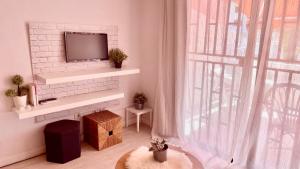 een woonkamer met een tv op een witte bakstenen open haard bij Los cristianos Vistas al mar y cerca de la playa in Los Cristianos