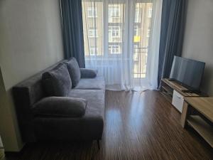 a living room with a couch and a television at Central station in Daugavpils