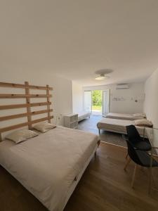 Un dormitorio con dos camas y un escritorio y una silla. en Domaine de PY, en Loubressac