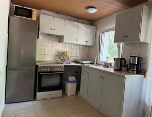 a kitchen with a stainless steel refrigerator and cabinets at Moustaki Apartments in Keramoti