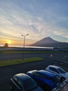a group of cars parked in a parking lot with a mountain at Casa mãe in Lajes do Pico