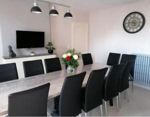 a dining room with a long table and black chairs at Rêve Chablisien in Chablis