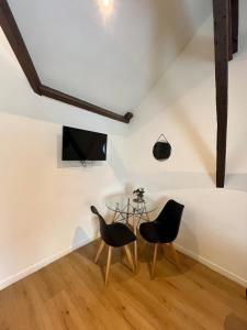 a dining room with two chairs and a glass table at Charme & calme en Centre ville à pied avec parking gratuit - Studio Oslo in Châtellerault +16 photos