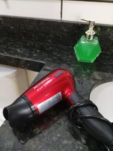 a blow dryer sitting on a counter next to a sink at Mini Garden kitnet in Paranavaí