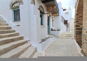 a group of stairs leading up to a white building at Meli House Cycladic traditional stone house-1895 in Platiá