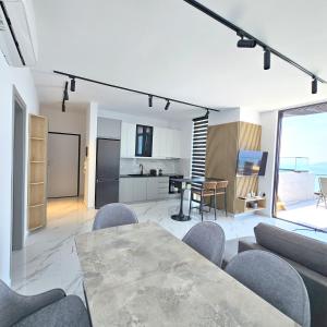 Una sala de estar con mesa y sillas y una cocina. en Penthouse Paradise, en Sarandë