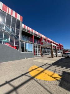 Un gran edificio con un círculo amarillo delante. en Nkandla Lifestyle, en Mthatha