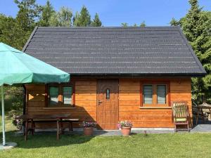 a small wooden cabin with a picnic table in front of it at GAJÓWKA JAMNA NOCLEGI in Jamna