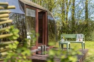 a small glass house with a table and a chair at Cabin Fata Morgana in Kats
