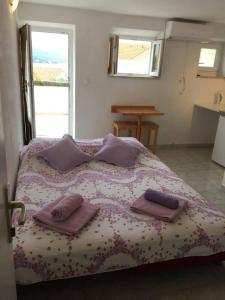 1 dormitorio con 1 cama con 2 almohadas en Linda Apartment, en Korčula