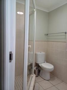 a bathroom with a toilet and a glass shower at Point Village Accommodation - Santos 57 in Mossel Bay +12 photos