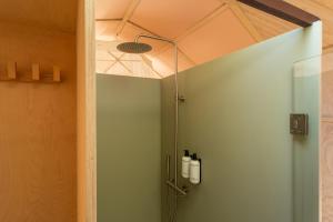 a shower with a glass door in a bathroom at Cabin Fata Morgana in Kats