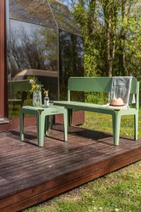 a green bench and a table on a deck at Cabin Fata Morgana in Kats +3 photos