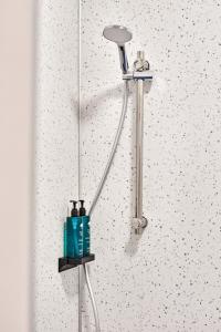 a shower head with two bottles on a wall at Princess Blue 1 ~ Fabulous Apt in Perfect Location in Portrush +23 photos