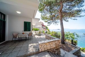 a patio with a table and chairs next to the water at Apartments Bisko in Prizba