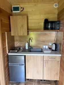 a kitchen with a sink and a microwave at GAJÓWKA JAMNA NOCLEGI in Jamna
