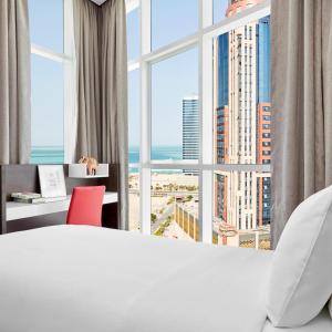 A bed or beds in a room at Staybridge Suites - Doha Lusail by IHG