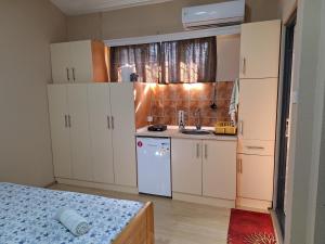 a small kitchen with white cabinets and a sink at Goka apartments in Gevgelija