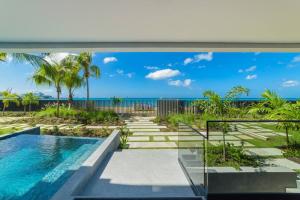 a view of the ocean from a house with a swimming pool at Allure 502, Beachfront Penthouse by ZenBreak in Bridgetown